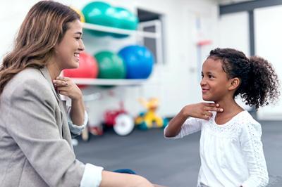 Woman doing sign language with young girl